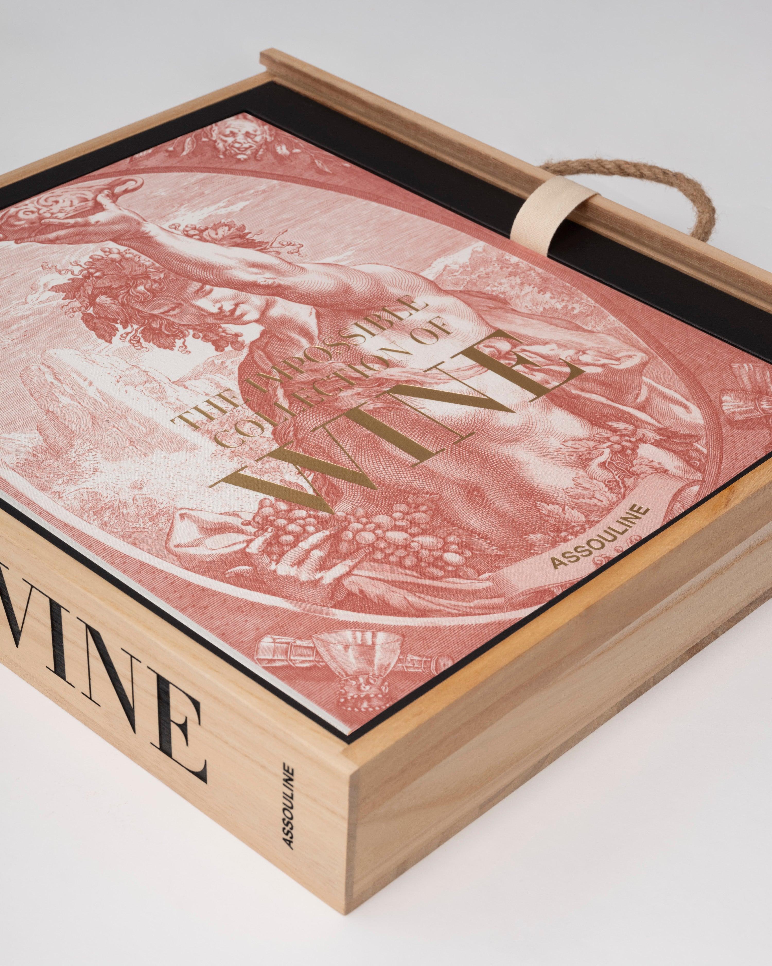 Libro de vino Assouline semi-extraído de su caja de madera, revelando la tapa con ilustración clásica.