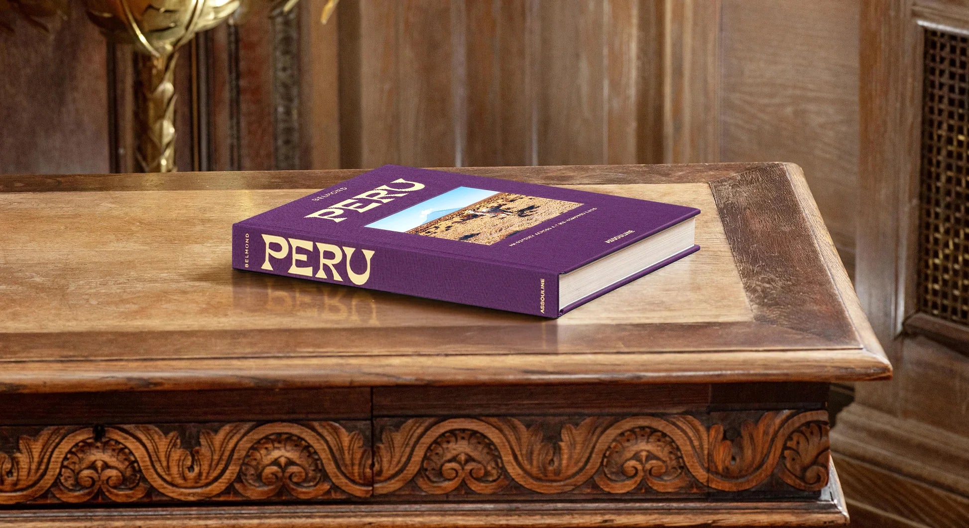 Libro Assouline Perú sobre mesa de madera tallada. Decoración elegante para interiores de lujo.