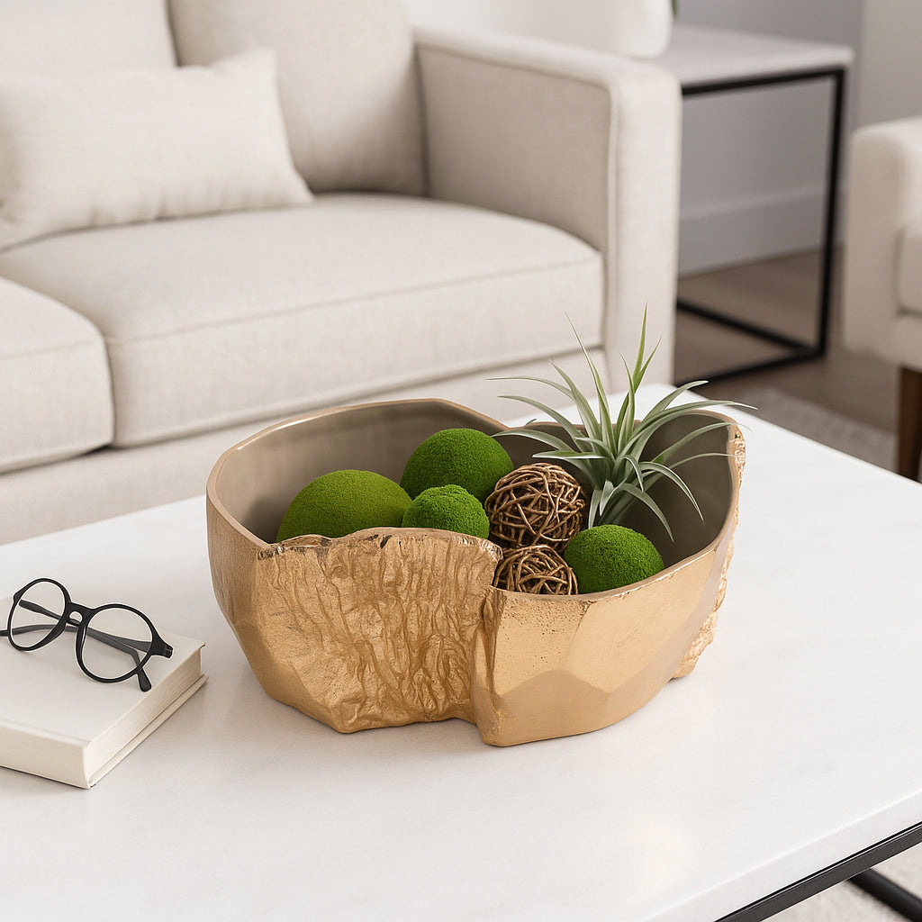 Bowl decorativo dorado en centro de mesa de sala moderna con bolas de musgo y planta aérea.