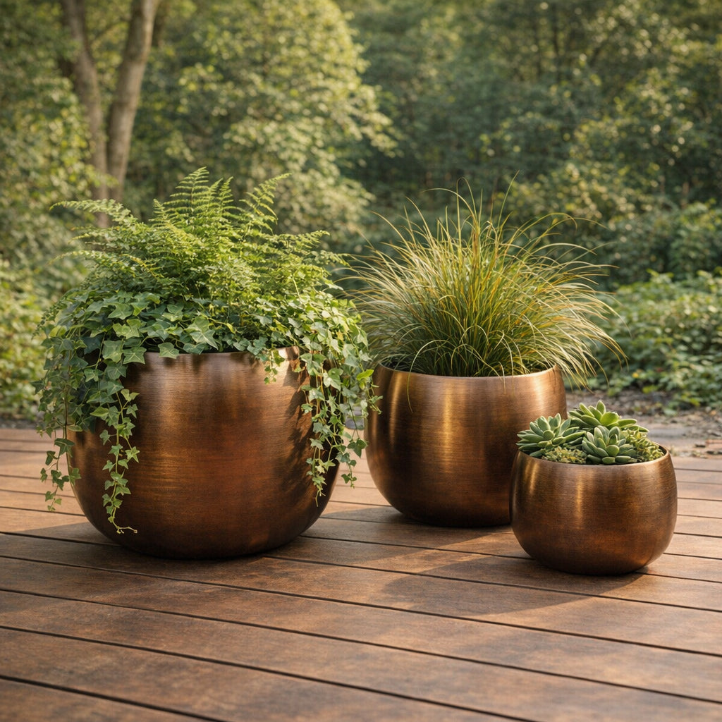 Juego de macetas metálicas estilo cobre en terraza de madera con plantas decorativas.