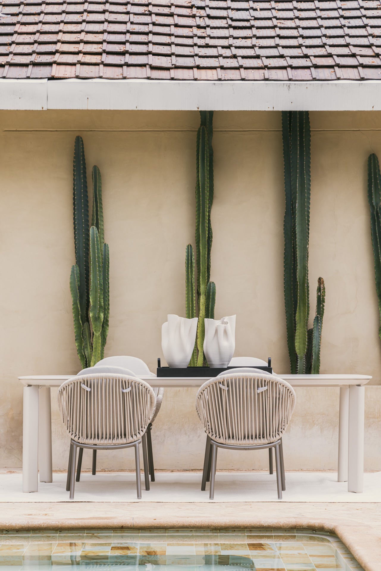 Sillas de exterior Vilá Decoración en un patio con piscina, ideal para relajación y lujo.