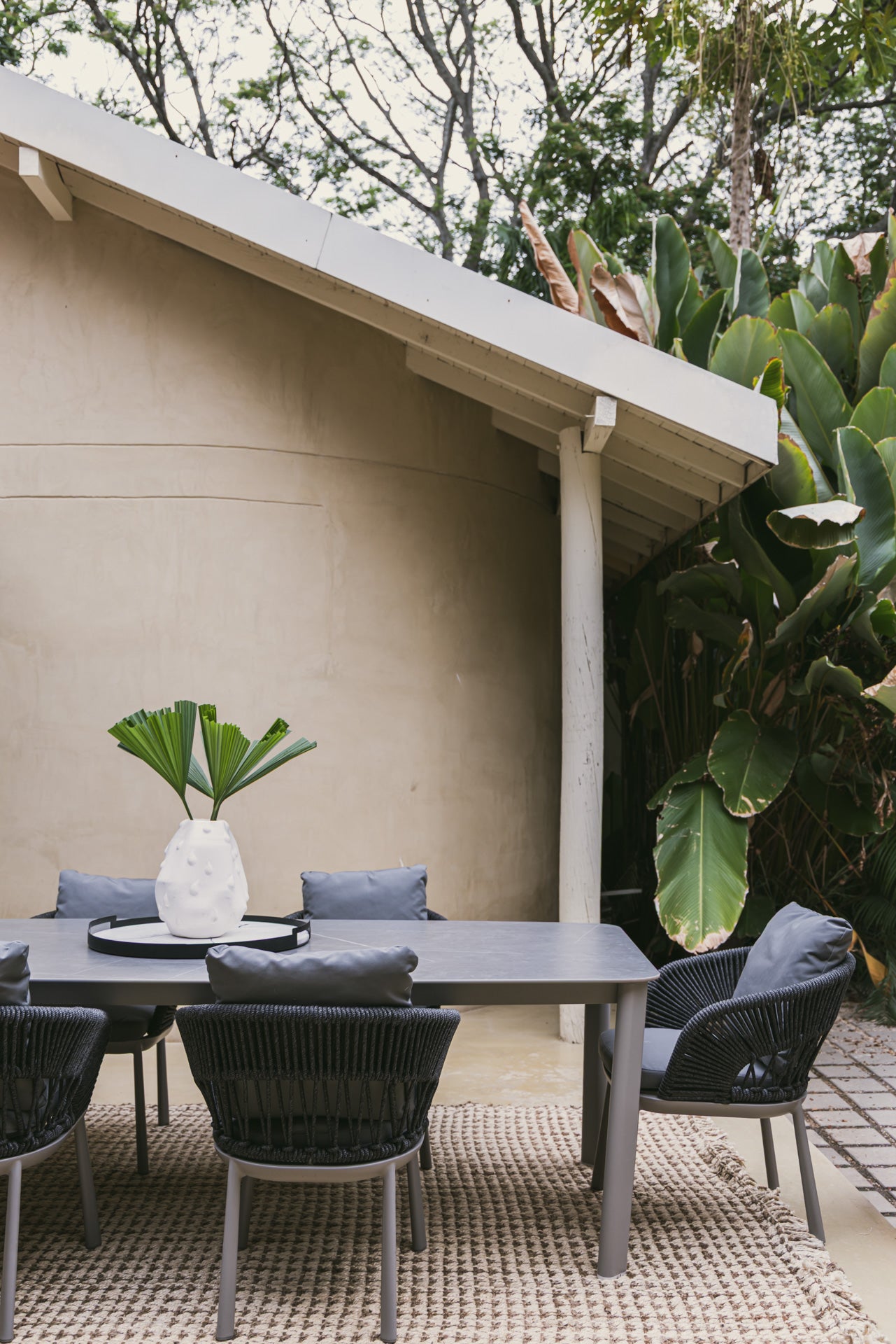 Ambiente de lujo con mesa comedor exterior de diseño contemporáneo y sillas en terraza.