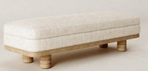Banca Kael ottoman de lujo tapizado en tela texturizada crema con base y patas de madera clara