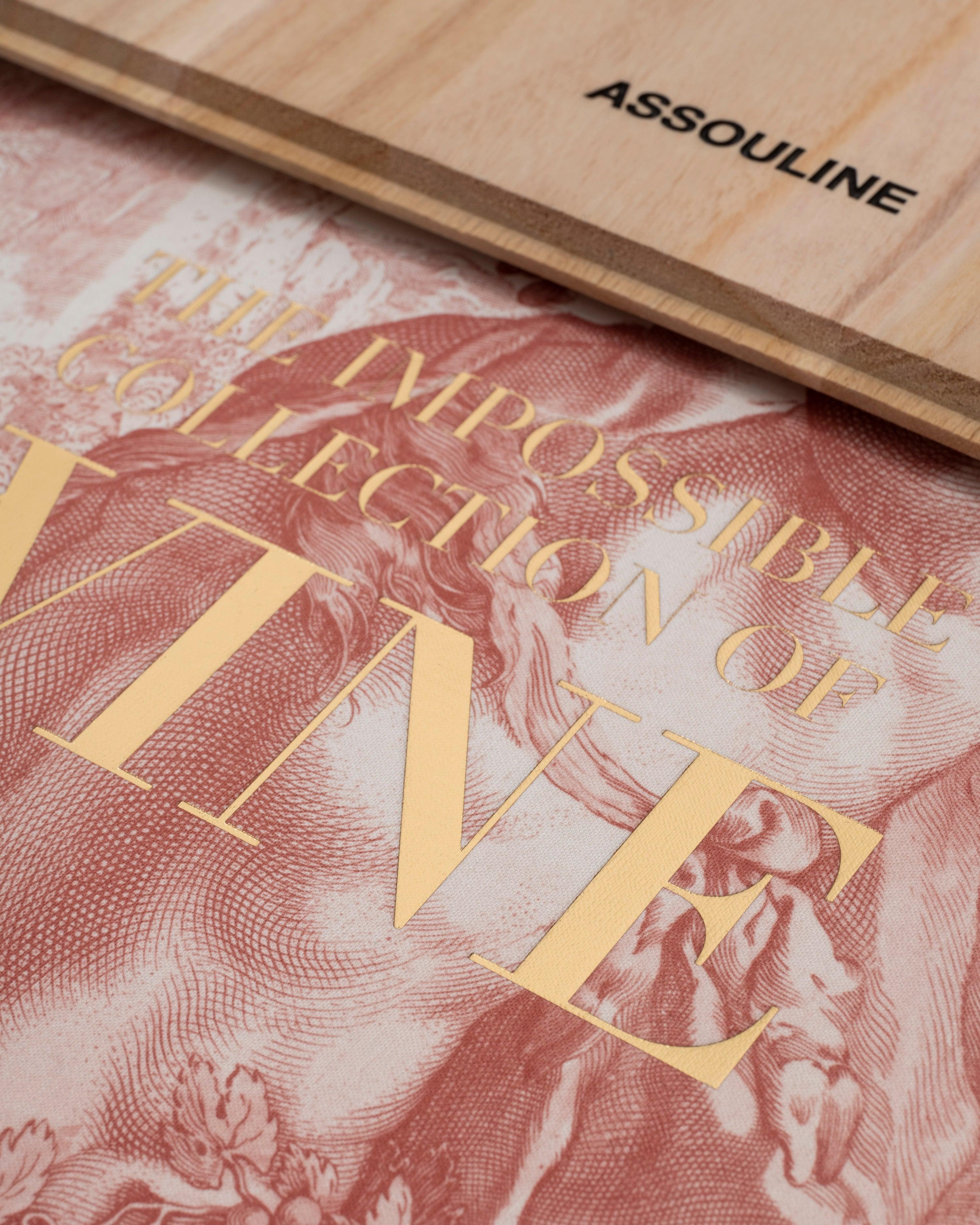 Primer plano del libro Assouline The Impossible Collection of Wine, mostrando detalles dorados y diseño.