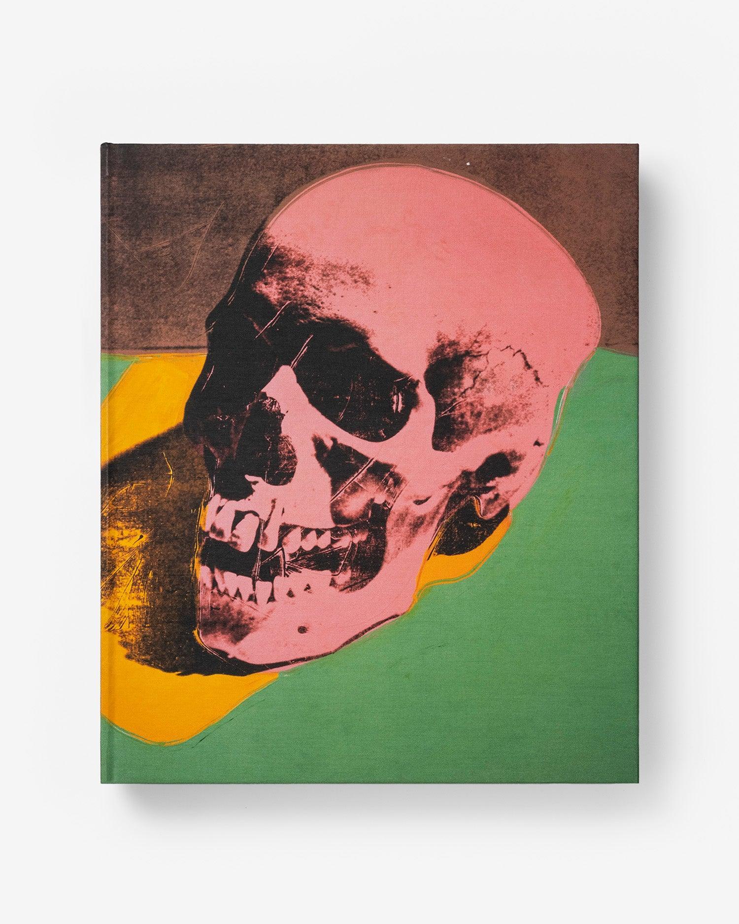 Portada del libro de lujo 'Andy Warhol: The Impossible Collection' de Assouline con diseño de calavera rosa vibrante.