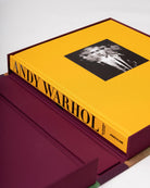 Libro 'Andy Warhol: The Impossible Collection' de Assouline abierto en su estuche protector color borgoña.