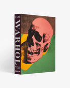 Libro 'Andy Warhol: The Impossible Collection' de Assouline de pie, mostrando la icónica calavera rosa en la portada y el lomo.