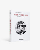 Libro de arte Self Portraits Assouline en estante, cubiertas blancas, detalles en rojo y negro.