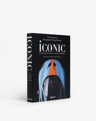 Libro decorativo Assouline Iconic de lujo, mostrando la portada con automóvil deportivo azul y naranja.