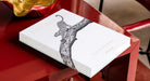 Libro de lujo Assouline Londolozi sobre mesa roja brillante, con cuenco dorado, realzando la decoración.