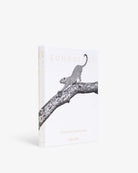 Libro decorativo Assouline Londolozi en blanco, con leopardo en rama y letras doradas, vista frontal.