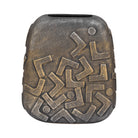 Jarrón decorativo moderno en tono bronce con textura rústica y patrón geométrico abstracto.