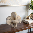 Nudo decorativo de travertino beige en consola de madera, aportando lujo y sofisticación a la decoración del hogar.