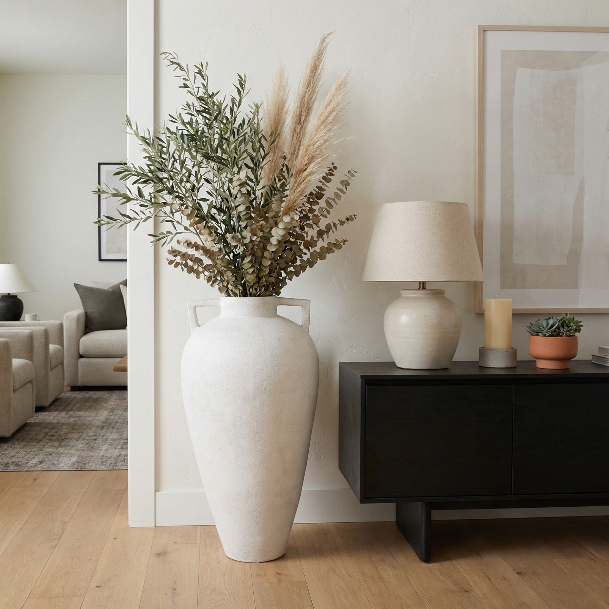 Jarrón de piso grande blanco con arreglos de flores secas en sala moderna y elegante.