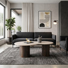 Mesa de centro de lujo en sala moderna con sofá gris, alfombra oscura y decoración minimalista.