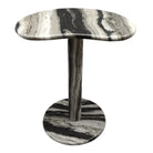 Mesa auxiliar de diseño exclusivo en patrón de piedra blanco y negro con base redonda y tope ondulado.