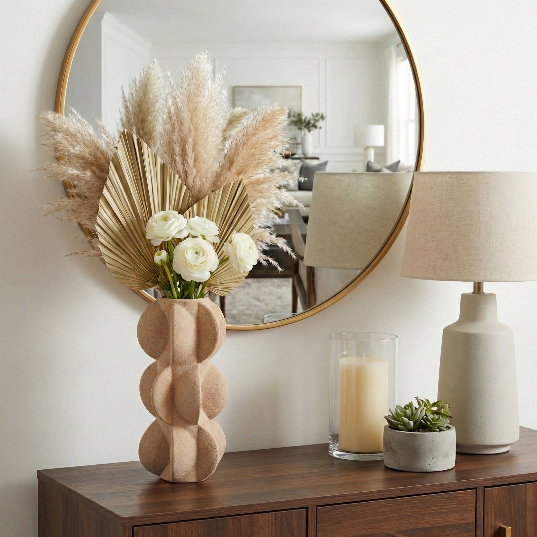Jarrón escultórico de arena con flores secas y blancas en mesa de madera, decoración elegante.