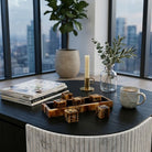 Juego decorativo de lujo en mesa de centro, con ventanas y skyline de ciudad. Ambiente sofisticado.