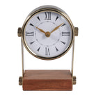 Reloj de mesa con diseño clásico, números romanos, estructura metálica dorada y base de madera oscura.