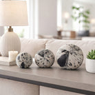 Esferas decorativas cowhide en sala moderna, adornando una consola junto a lámpara y planta.