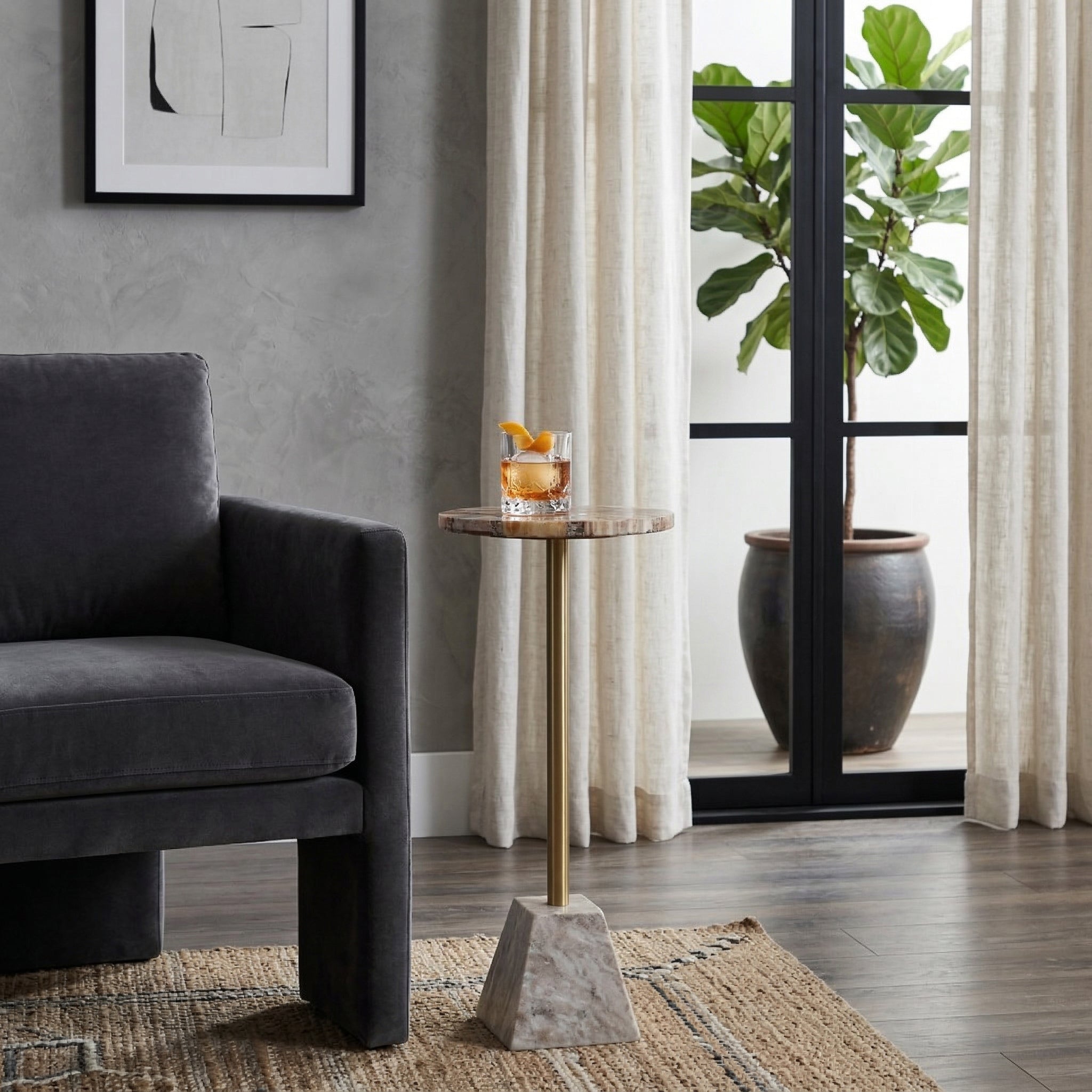 Mesa auxiliar de lujo con bebida en sala contemporánea, junto a sillón oscuro y planta grande.