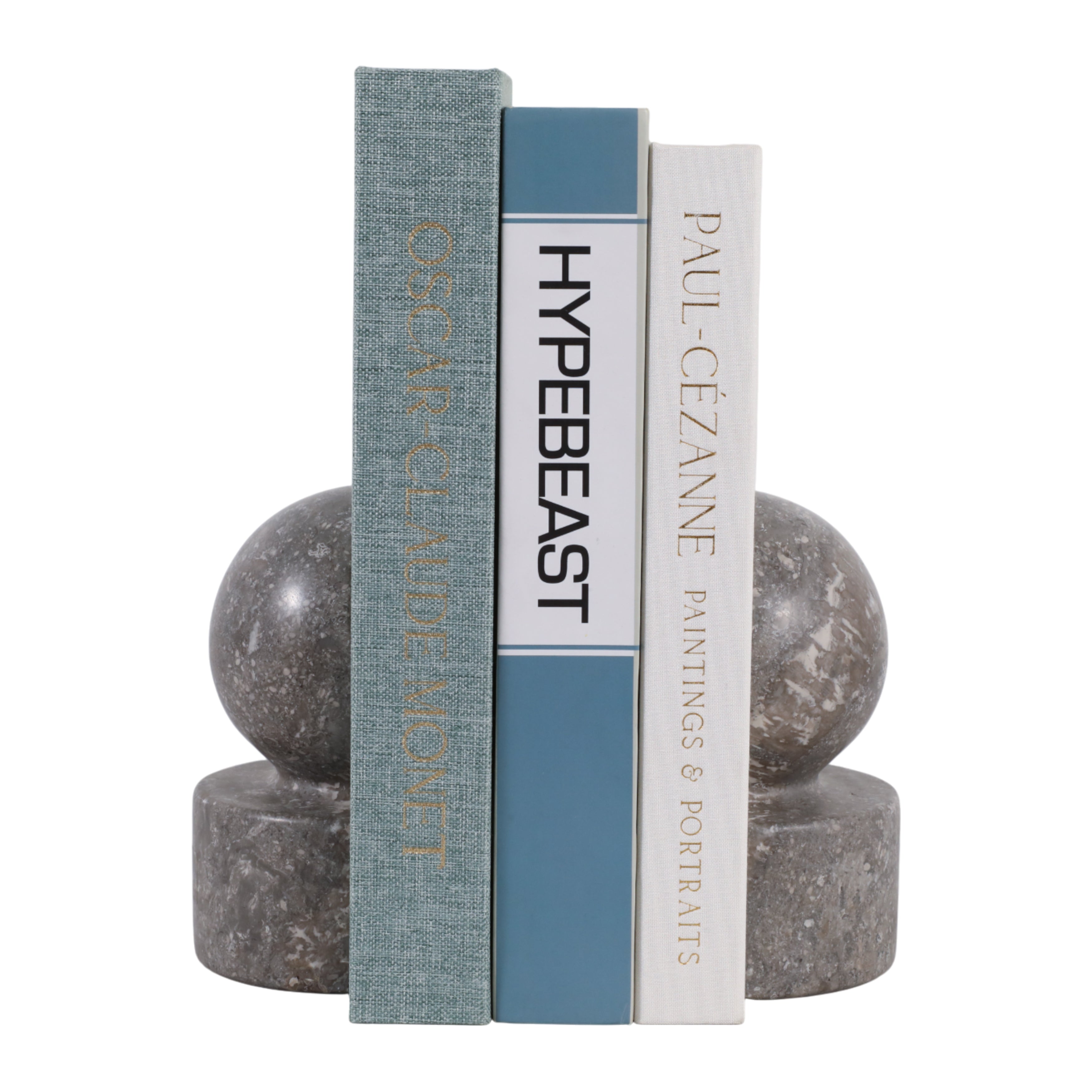 Par de sujetalibros de mármol gris con libros de diseño organizando una estantería moderna.