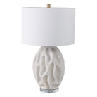 Lámpara de mesa blanca con base texturizada de diseño orgánico y pantalla de tambor blanca. Ideal para decoración moderna del hogar.