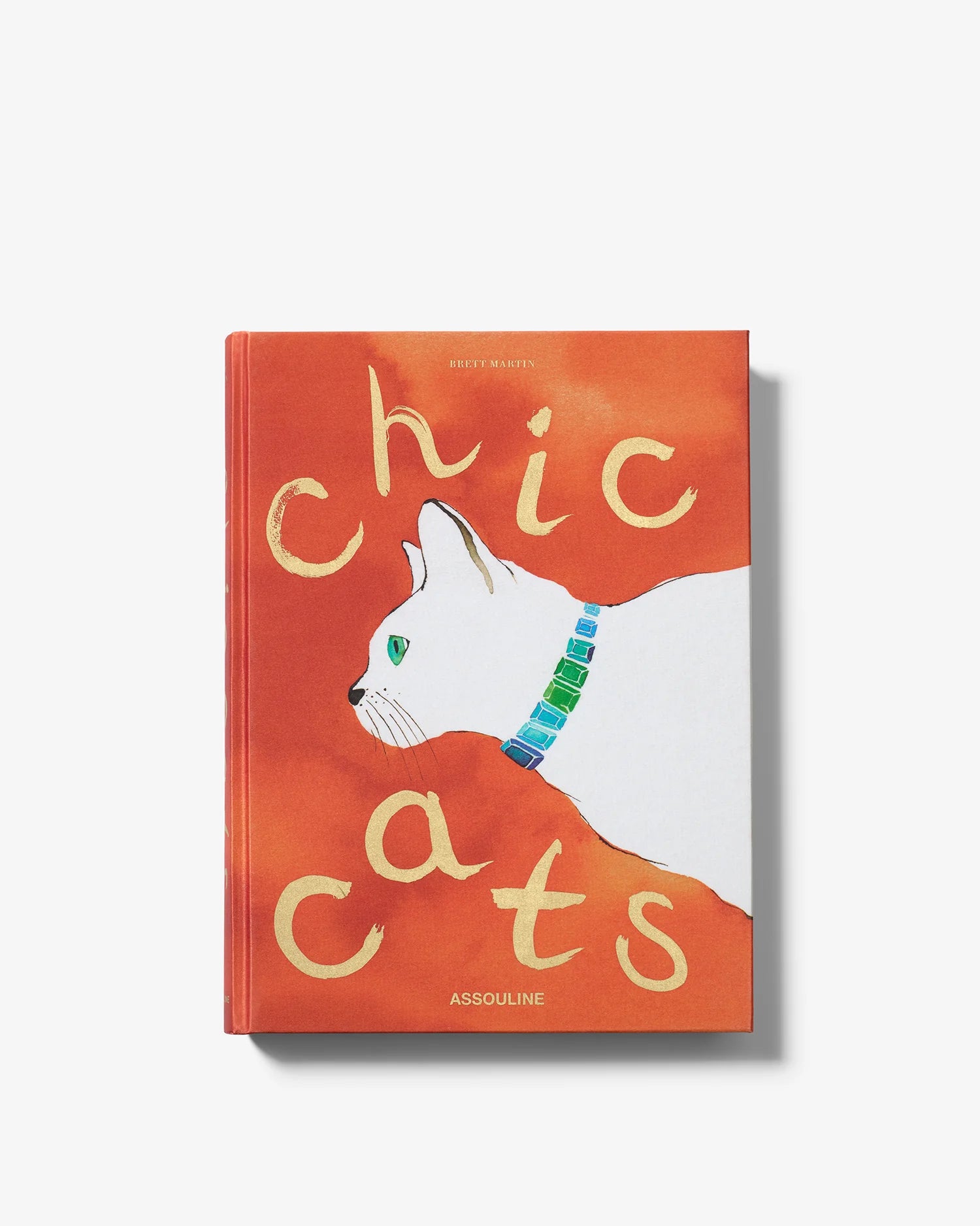 Libro de mesa Chic Cats de Assouline, vista frontal con ilustración de un elegante gato blanco sobre fondo naranja.