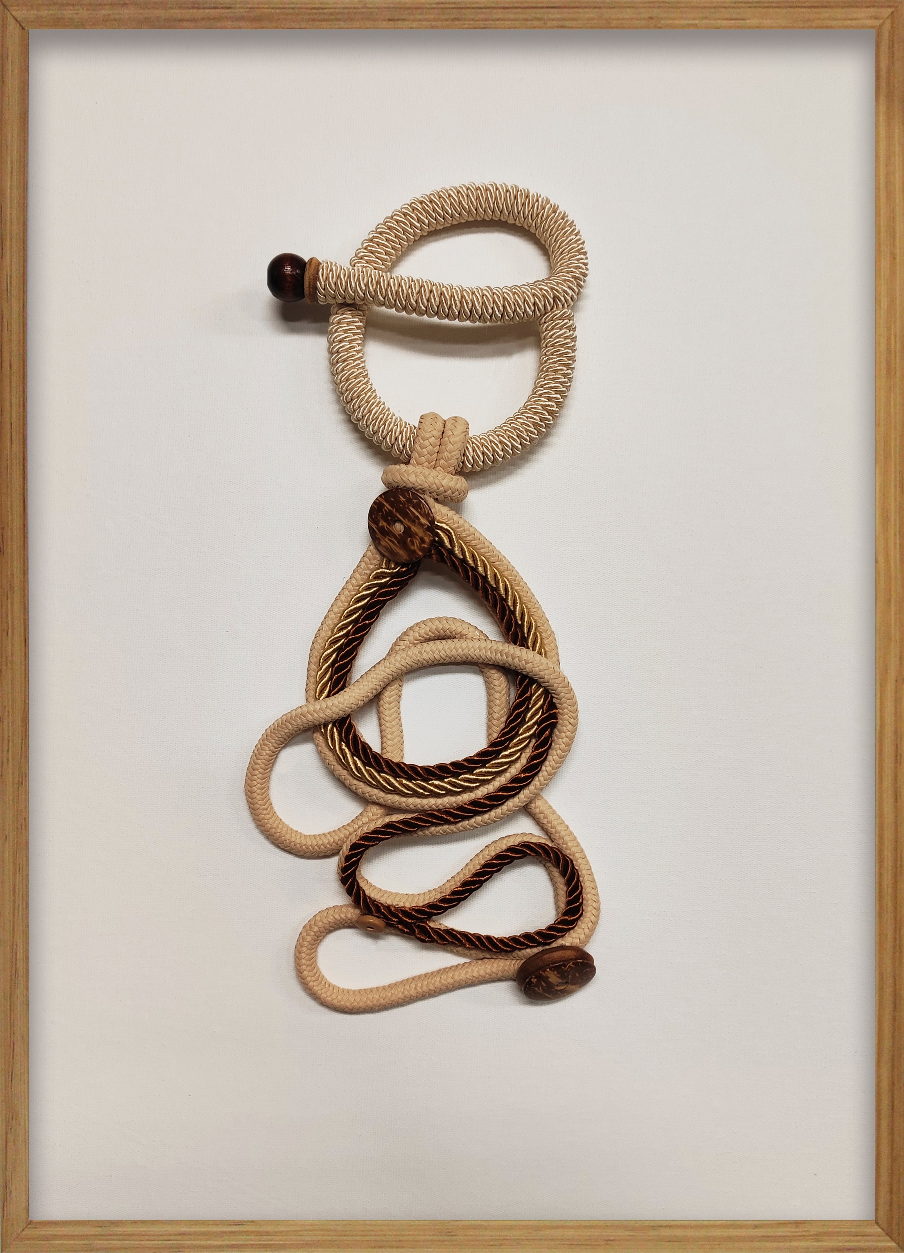 Cuadro de Vilá Decoración con marco de madera, fondo de tela blanca y diseño de cuerda de tela beige y marrón.