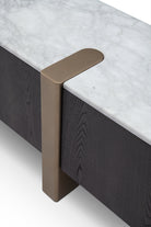 Detalle de mueble TV: mármol blanco veteado, madera oscura con textura y elegante acento metálico bronce.