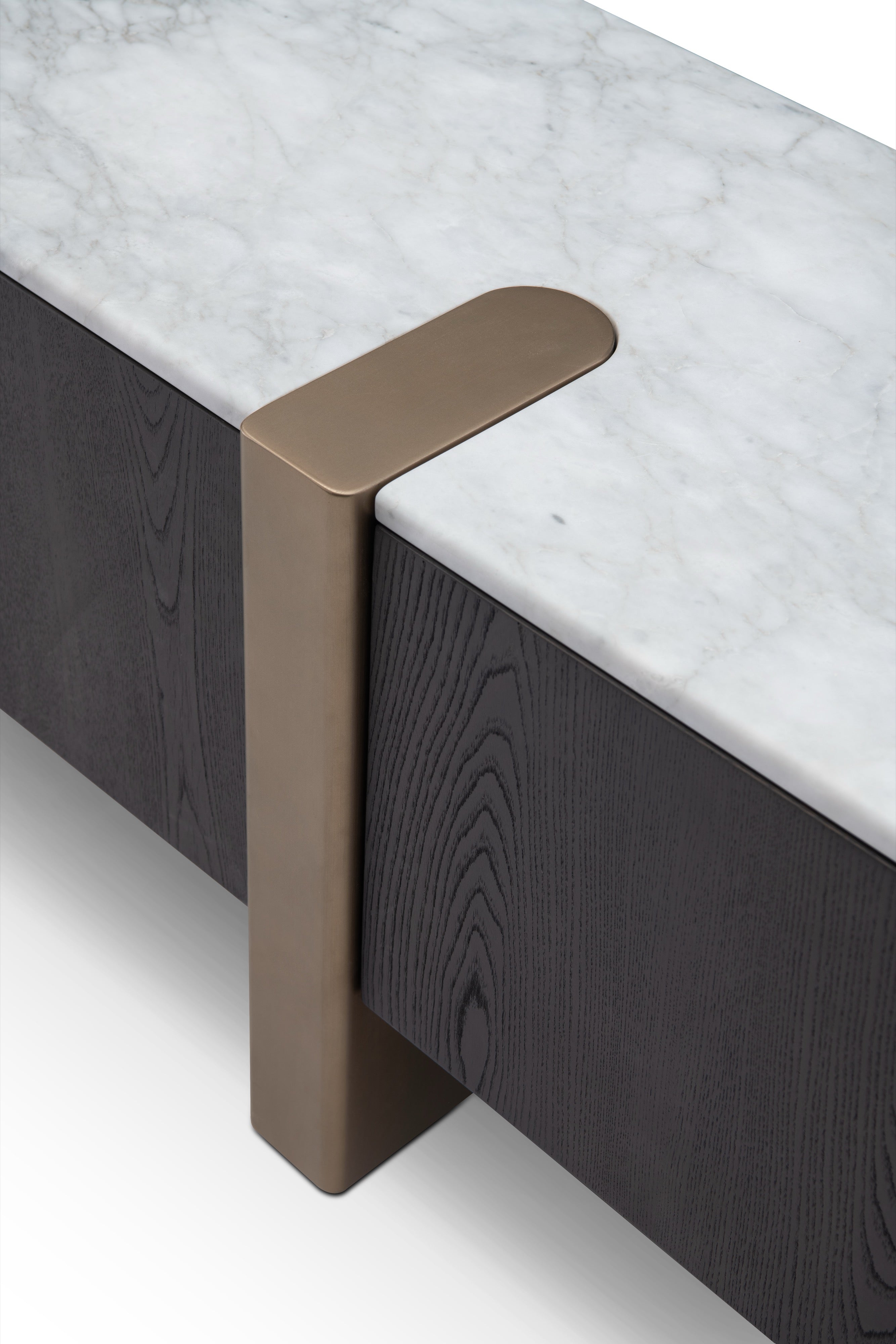 Detalle de mueble TV: mármol blanco veteado, madera oscura con textura y elegante acento metálico bronce.
