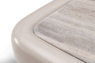 Detalle de esquina redondeada de mesa de centro de lujo con tapa de piedra natural beige.
