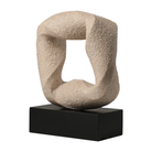 Escultura decorativa abstracta en resina beige, forma orgánica, sobre base negra rectangular, ideal