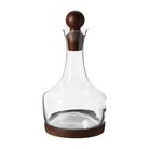 Jarrón decorativo de vidrio transparente con tapón y base de madera oscura, destacando su diseño