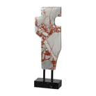 Escultura abstracta de mármol blanco con vetas rojas, sobre base de metal negro, ideal para