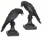 Set de dos candelabros góticos con figuras de cuervos negros sobre pedestales ornamentados para velas