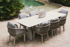 Conjunto completo de mesa comedor exterior de lujo con 8 sillas en un patio con plantas.