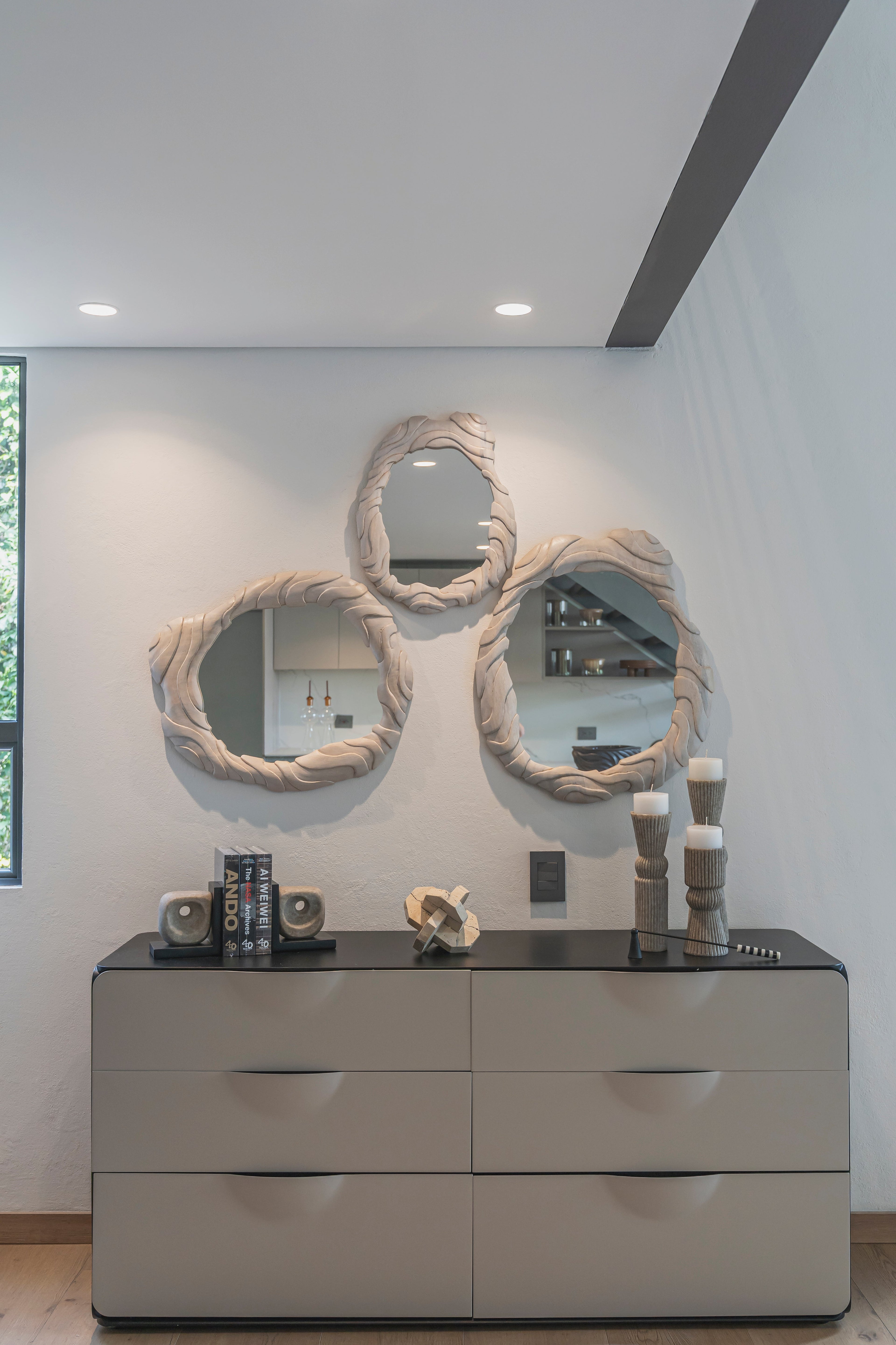 Espejos decorativos orgánicos en pared sobre cómoda moderna